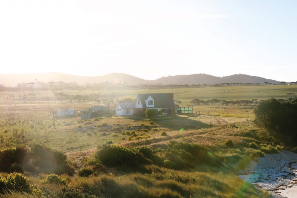 Ein einsames Haus entlang der Felder von Tasmanien. Kein seltener Anblick für Ania und Daniel während ihres Roadtrips über die kleine australische Insel.