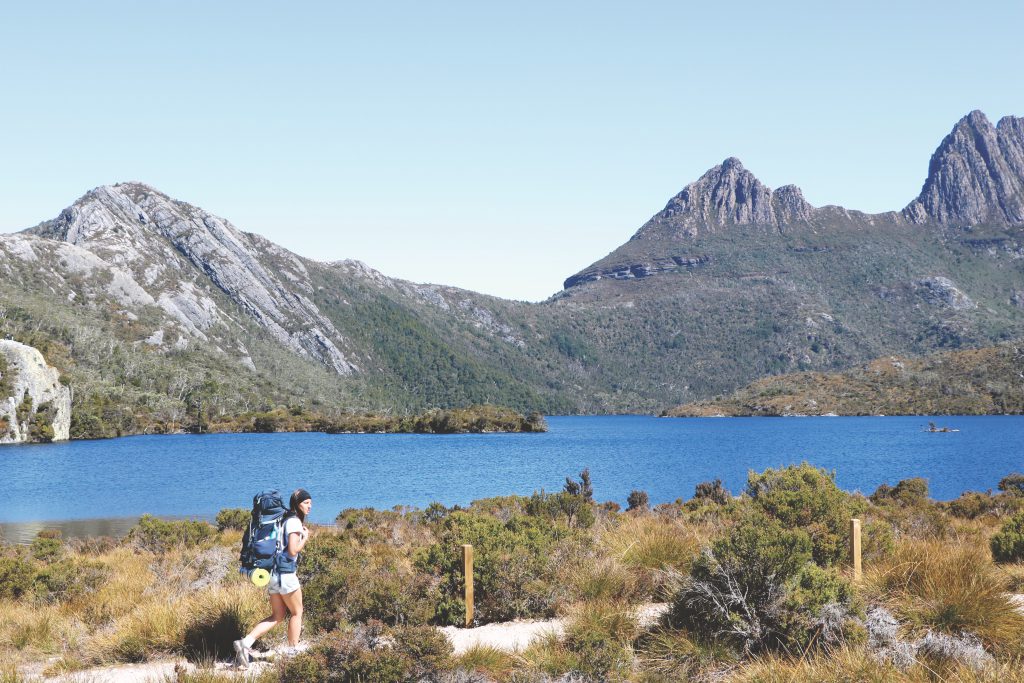 Ania wandert mit ihrem Rucksack entlang des Dove Lake Sees auf Tasmanien.