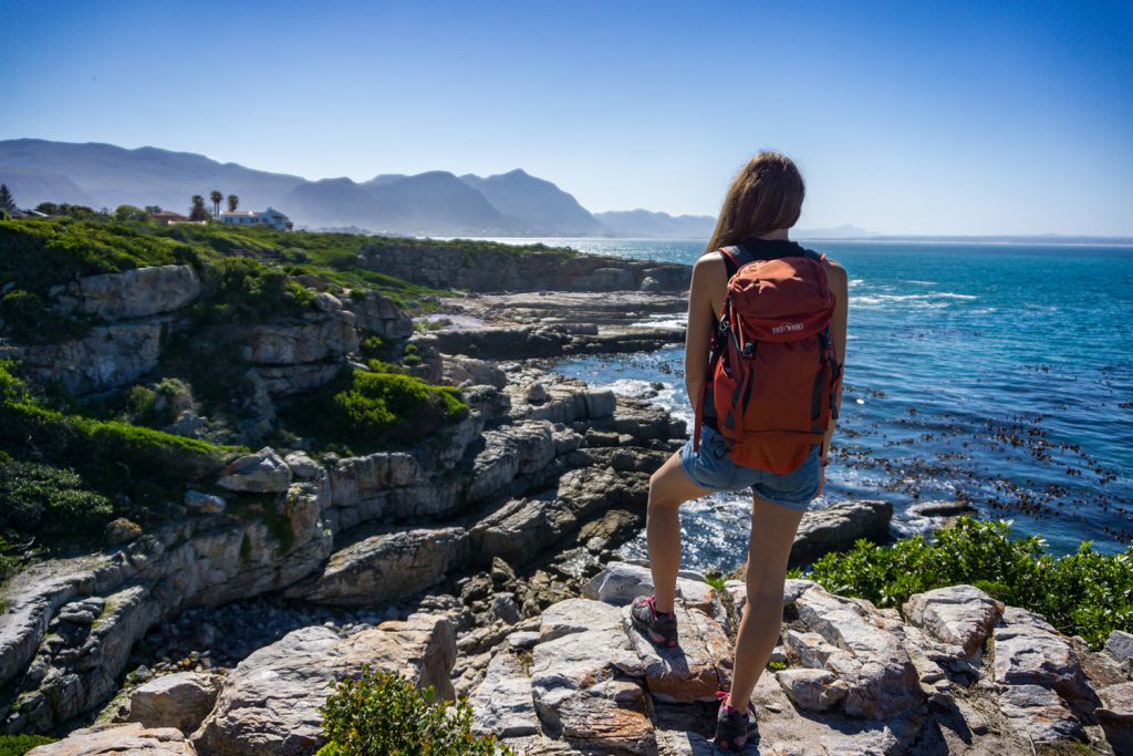Klicken, um Bild zu vergrößern. Garden Route Südafrika - Sara von blickt vom Cliff Path in Hermanus auf die vor ihr liegenden Berge und das Meer.