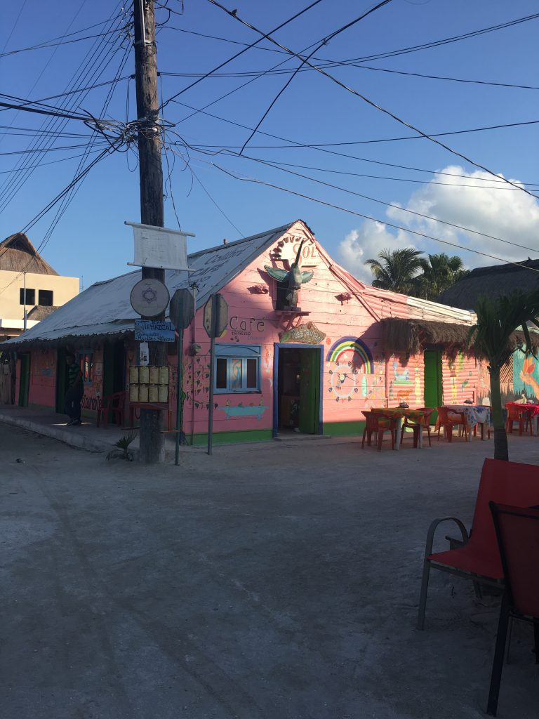 Roadtrip Yucatan - Kleines Cafe an einer Straßenecke in Holbox, Mexiko. Die wände sind mit rosa Farbe bemalt.
