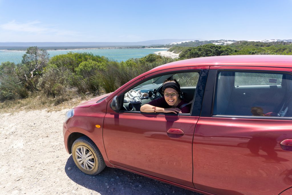 Garden Route Südafrika - Sara schaut aus dem Fenster ihres roten Mietwagens.