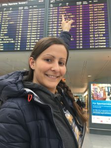 Auf dem Weg zum Roadtrip Yucatan - Sophie zeigt am Flughafen München auf die Anzeigentafel. Es geht nach Mexiko. 