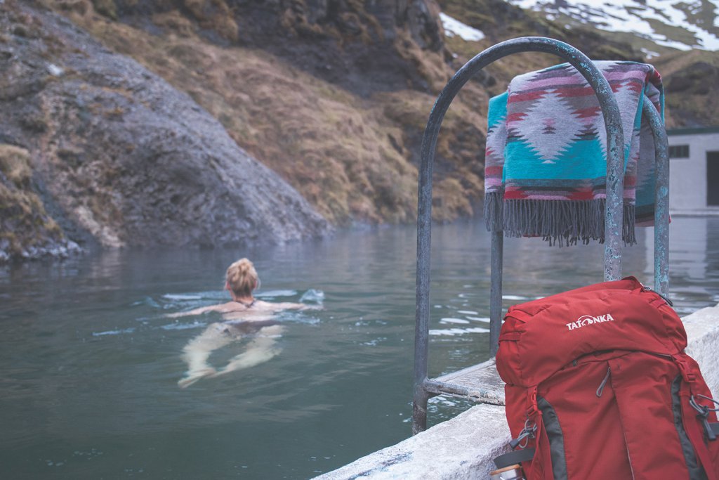 Line nimmt ein Bad im Seljavallalaug Schwimmbad.