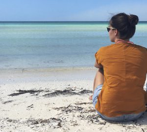 The Trekkin' Crew in Yucatan, Mexiko - Sophie sitzt am Strand und genießt das Rauschen des Meeres.