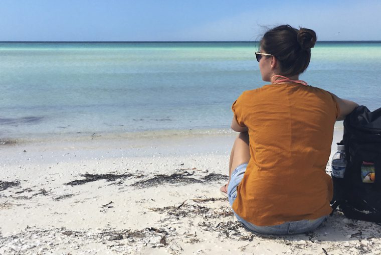 The Trekkin' Crew in Yucatan, Mexiko - Sophie sitzt am Strand und genießt das Rauschen des Meeres.