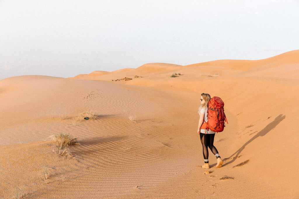 Joanna mit ihrem Tatonka Yukon Trekkingrucksack auf dem Rücken in der Wahiba Sands Wüste im Oman.