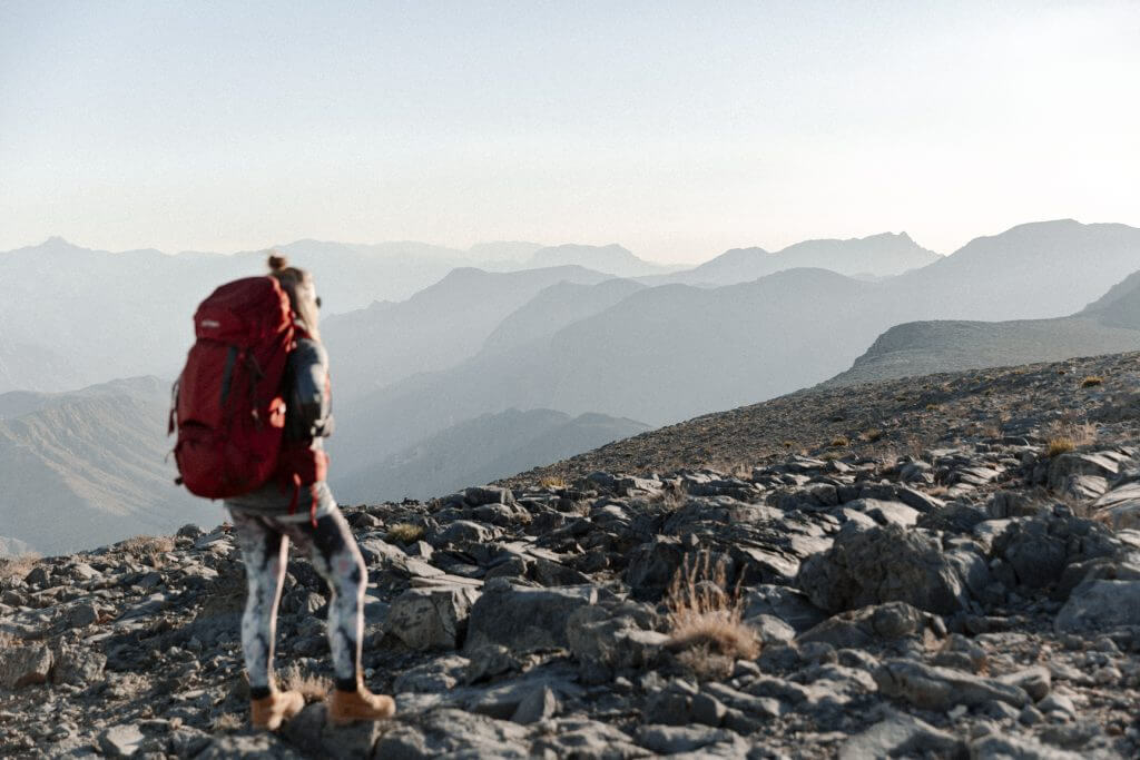 Joanna erkundet mir ihrem Yukon Trekkingrucksack die steinige Berglandschaft von Khasab im Oman. 