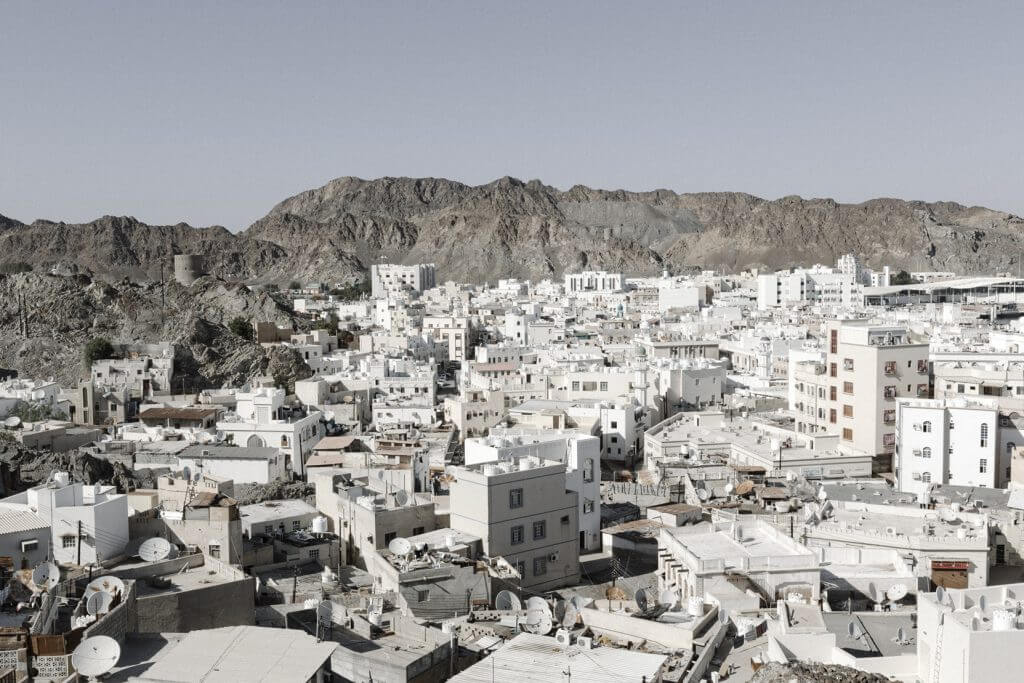 Blick von oben auf die weissen Häuser einer Stadt im Oman.