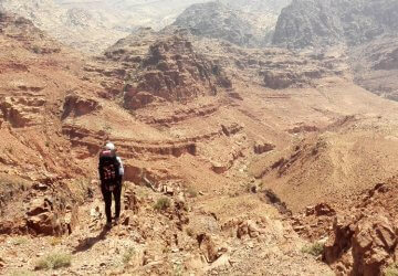 Trekken durch Jordanien - Jennifer blickt auf die karge aber beeindruckende Landschaft nahe Feynan in Jordanien.